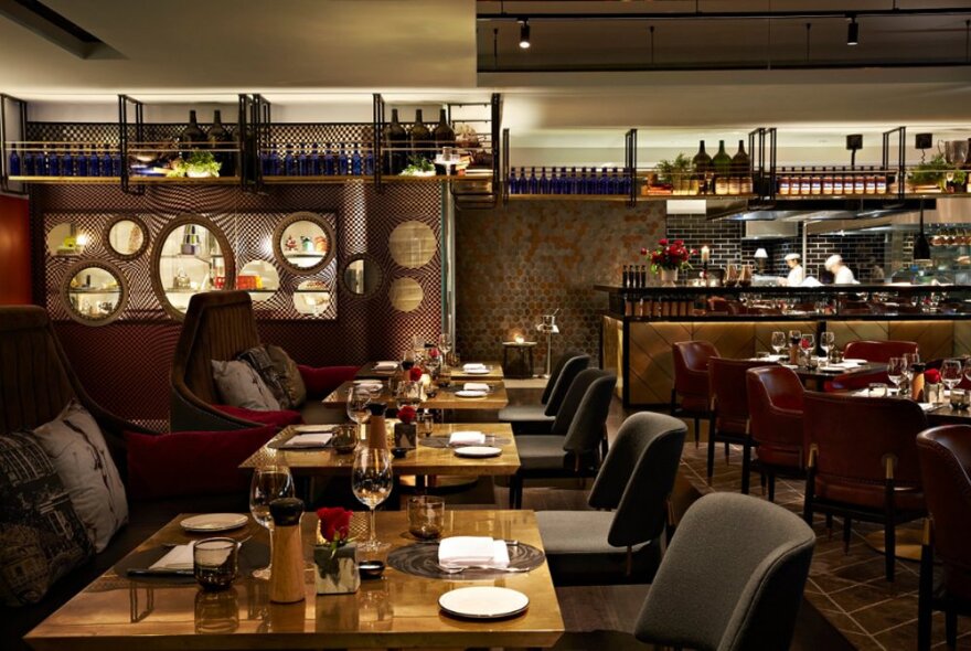 The interior of Pascale Bar & Grill showing dining tables set for service, and a view into the kitchen.