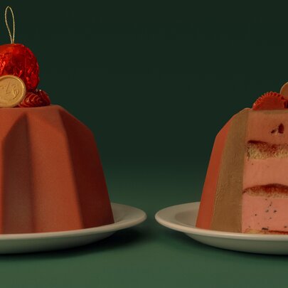 Two chocolate Christmas cakes, one a cross-section, with a red bauble on top. 
