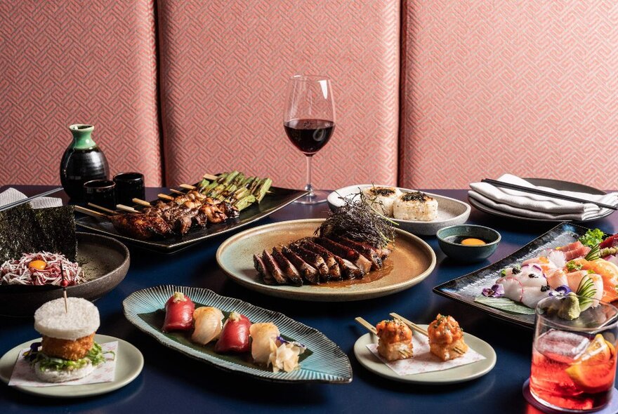 A table spread with many different Japanese dishes and drinks.