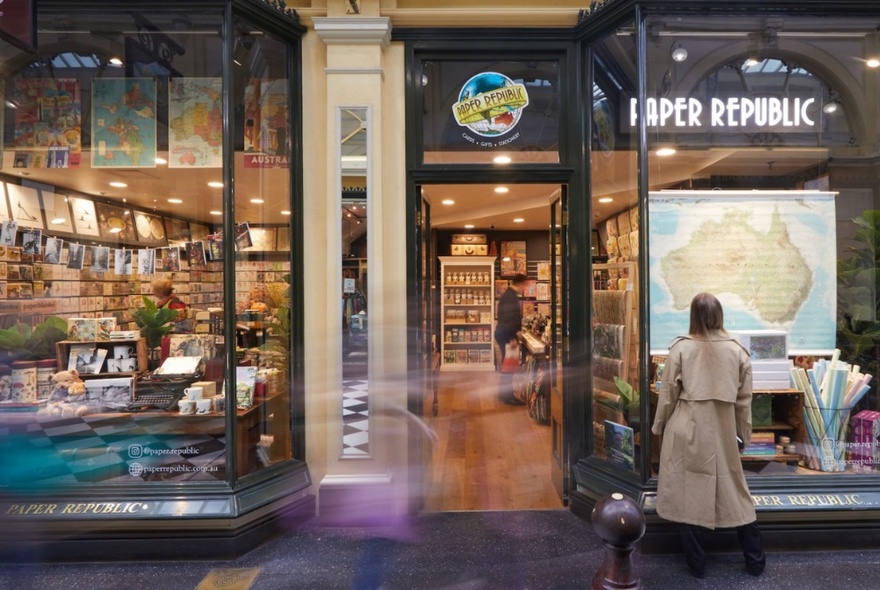 Person looking in through the external shop front windows of the Paper Republic business in Royal Arcade.