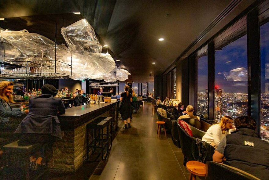 People enjoying drinks at a sophisticated cocktail bar on the 55th floor.