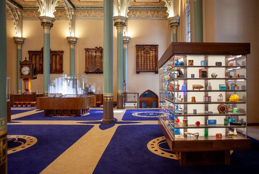 The interior of the Gothic Bank and the ANZ Banking Museum with a large glass display case on the right, and other items on display.