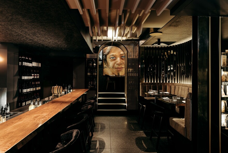 Inside a dimly-lit restaurant, showing a long bar and several tables.