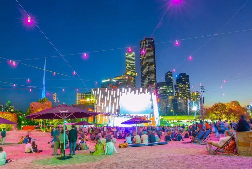 Crowds watching a performance at Fed Square at night.