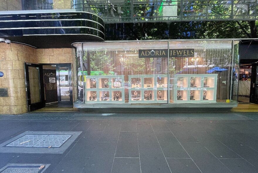 Jewellery store Art Deco shopfront with curved doorway and large plate-glass-screened window display with signage and display shelves.