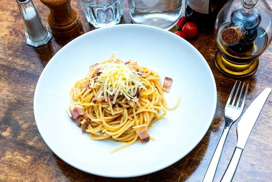 Plate of spaghetti with grated cheese.