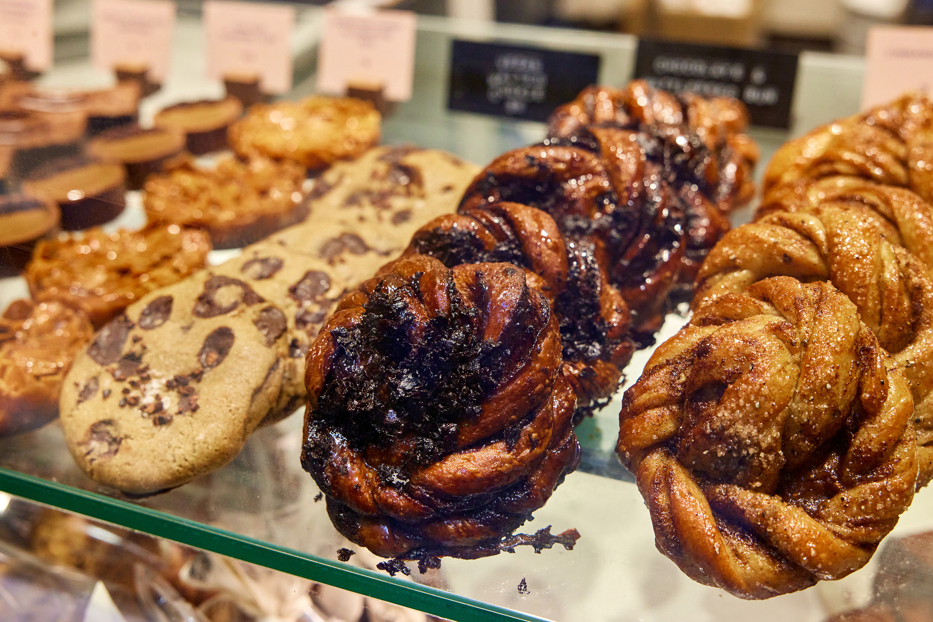 Cardamon scrolls are displayed in a bakery cabinet