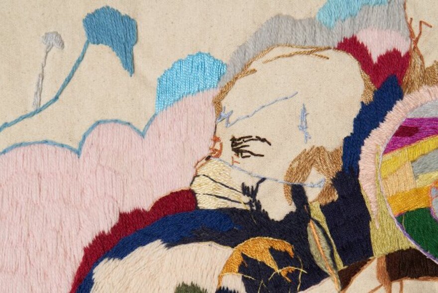 Embroidered artwork with head and face.