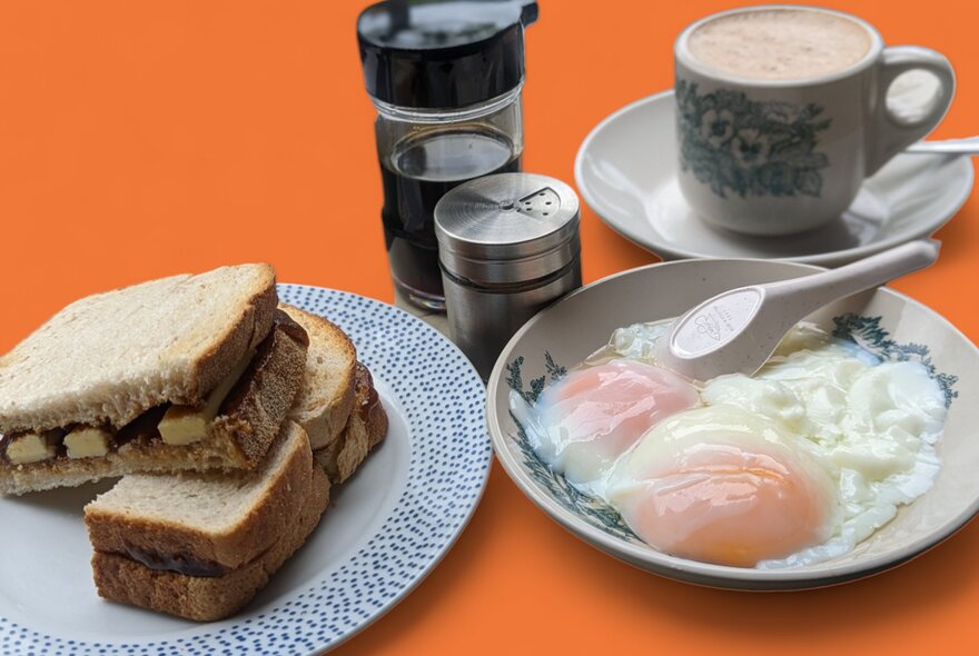 Looking at an orange table with poached eggs, a wholemeal sandwich and a cup of coffee.