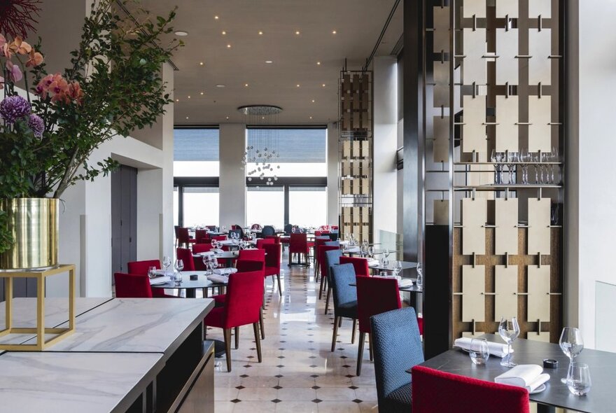 Interior of No35 with red chairs arranged around small square dining tables, a black and white tiled floor.