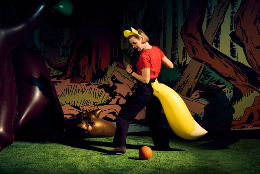 A woman in a woodland scene wearing a large yellow fox tail and fox ears.