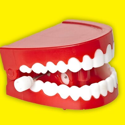 Novelty wind-up chattering teeth against a yellow background.