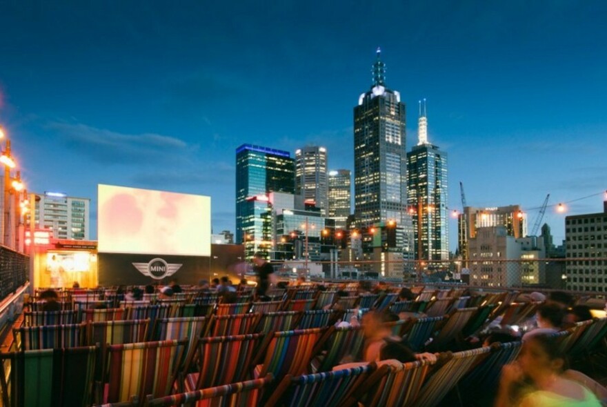 Rooftop cinema and deckchairs on top of Curtin House at night.