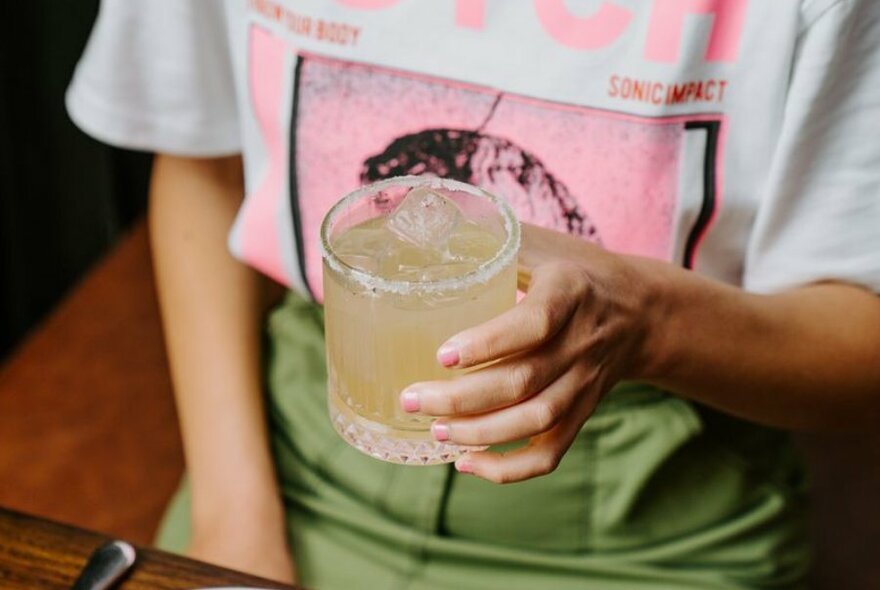 A woman's hand holding a margarita