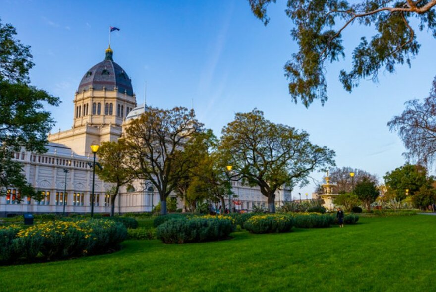 Wide shot of the Royal Exhibition Building in Carlton Gardens in front of a blue sky.