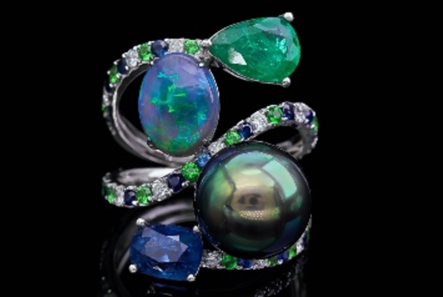 Ornate and intricate jewellery piece comprising opals and a black pearl and other blue and green gemstones.