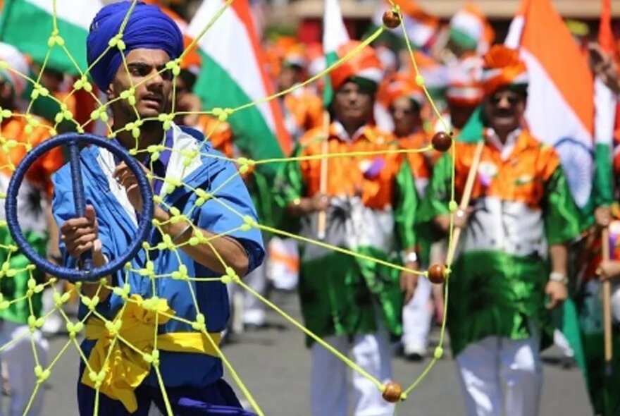 People wearing the colours of their nation walking in a street parade.