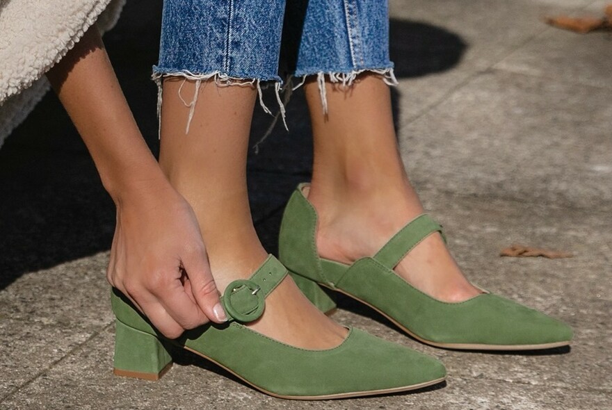 Woman wearing a pair of green shoes.