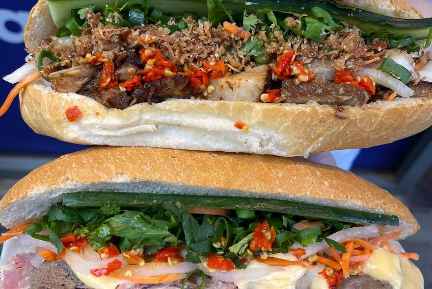 Two Vietnamese Banh Mi rolls showing filling options including coriander leaves, roast pork, chilli and cheese.