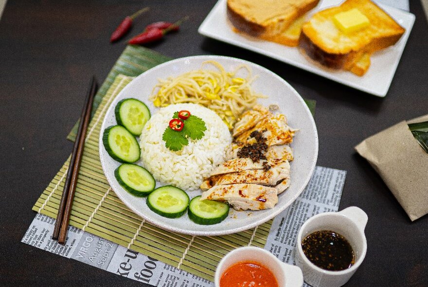 A plate of Hainanese chicken rise with condiments. 