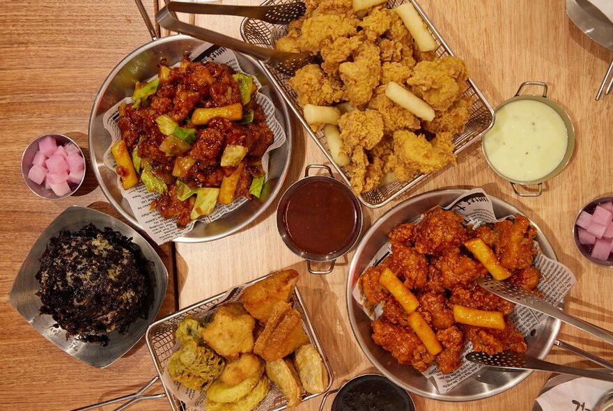 A restaurant table full of fried chicken and other Korean dishes.