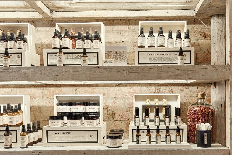 Shelves holding a display of beauty products in a stylish boutique.