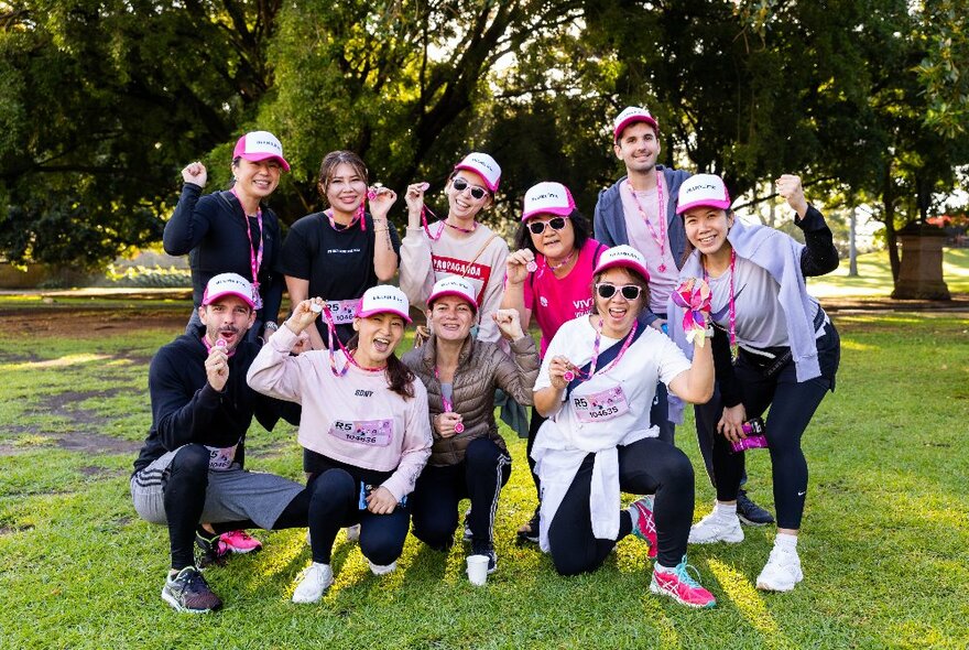 A group of Mother's Day Classic fun run participants, most wearing pink, showing their finish medals after completing the course.