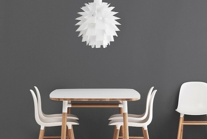 Danish furnishing display with white and wood table and chairs, and artichoke pendant light fitting.
