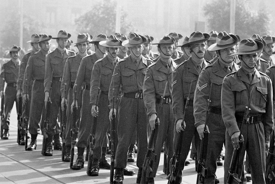 A street parade of men in Australian 'digger' military uniforms; a black and white image dating from the mid-1970s.