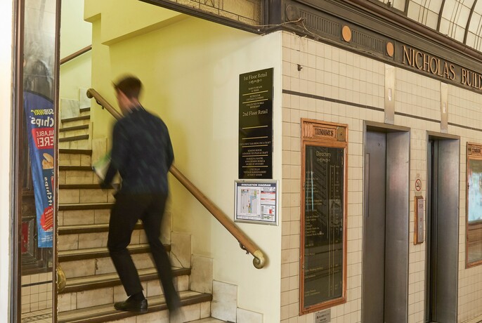 Person climbing the stairs at heritage-listed Nicholas Building.