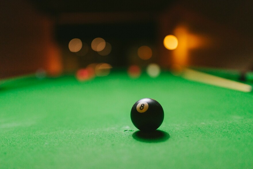 Number 8 ball on green pool table.