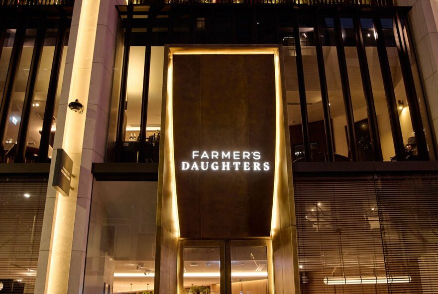 Street view looking up at the entrance to Farmers Daughters, showing rooftop area and signage above the door.