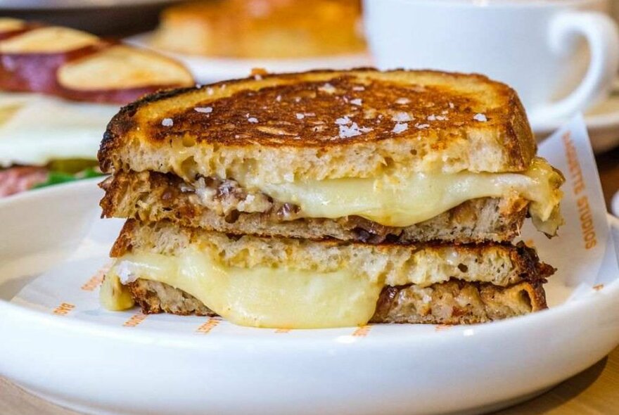 A grilled cheese toastie on a white plate.