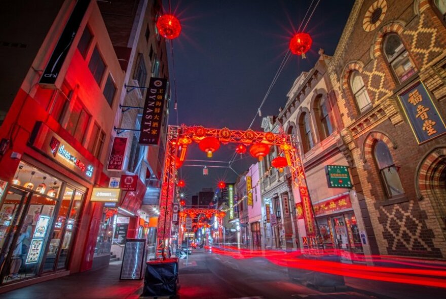 Melbourne's Chinatown at night with red lanterns and the glowing red lights of traffic.