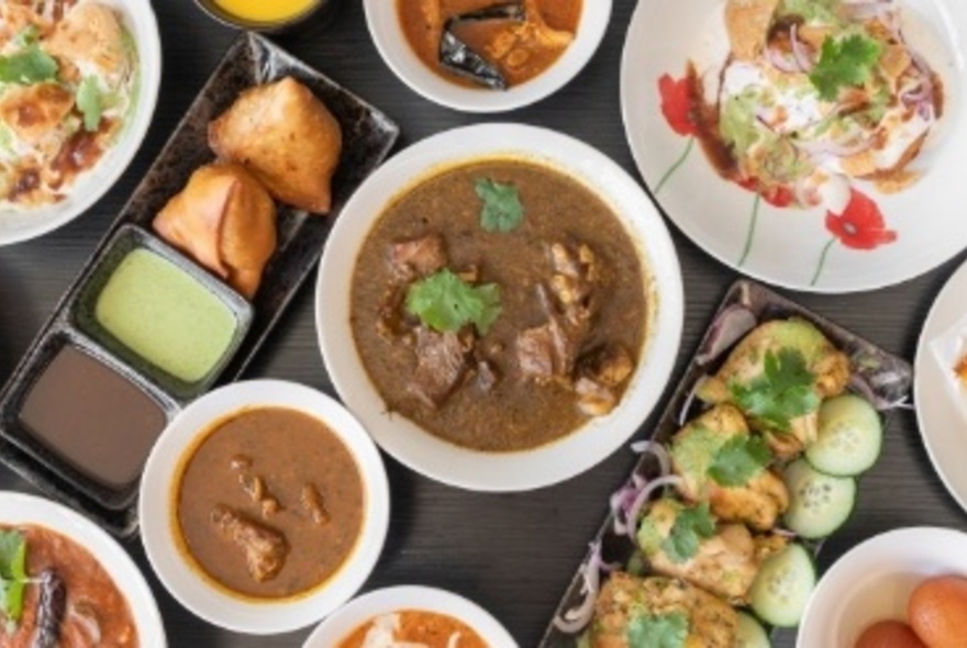 Bird's-eye of numerous dishes including curries and pakora.
