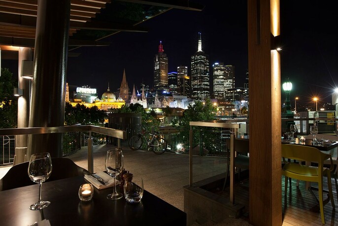 Restaurant table at night with city buildings lit up in the background.