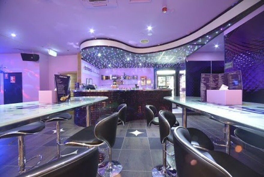 Interior of Stars KTV and Lounge karaoke bar showing bar area with bar stools.