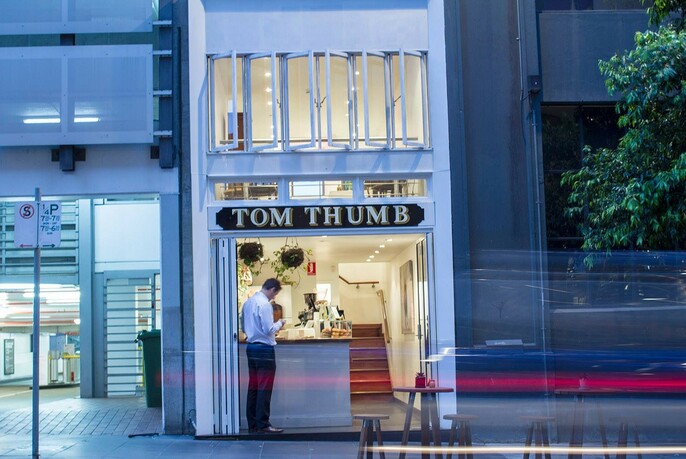 Exterior of Tom Thumb with a customer waiting outside.