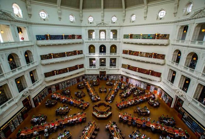 The inside of a library with a grand domed ceiling.
