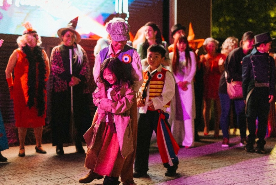 Adults and children dressed in costumes from well-known musicals.