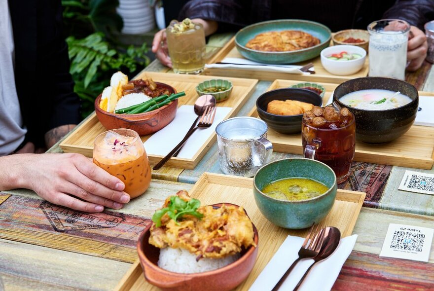 A table filled with Thai dishes and drinks