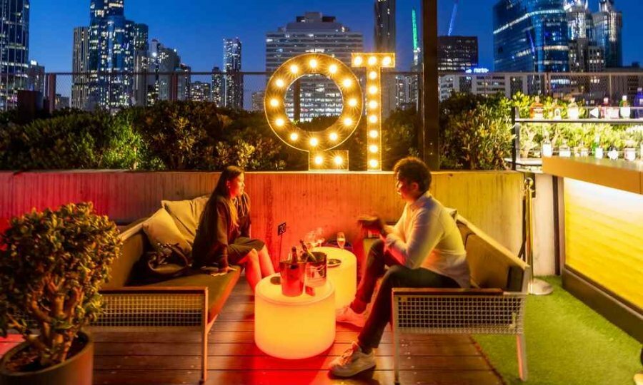 A couple dining at night at a rooftop bar