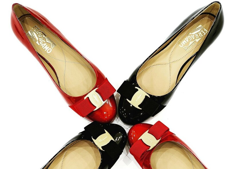Two pairs of red and black patent-leather mules with buckle details.