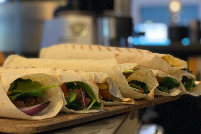 A row of wraps on a wooden board.