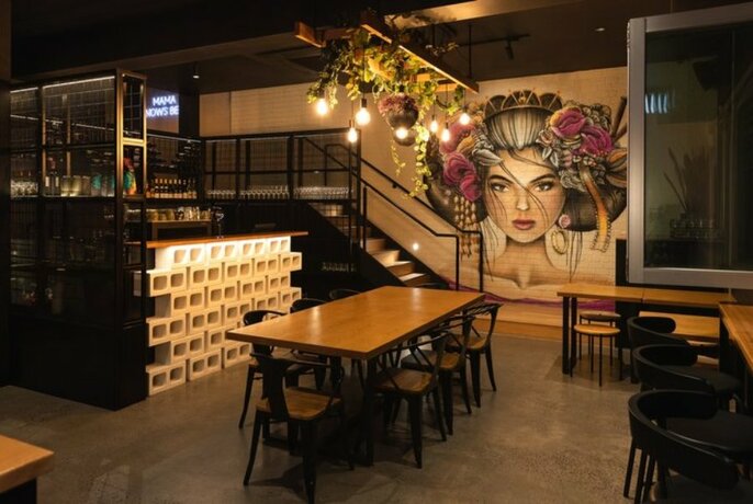 The interior of a restaurant with a woman's face painted on one of the walls.