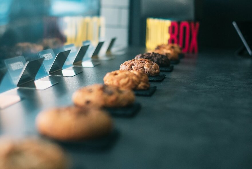 A row of cookies on display in a shop window.