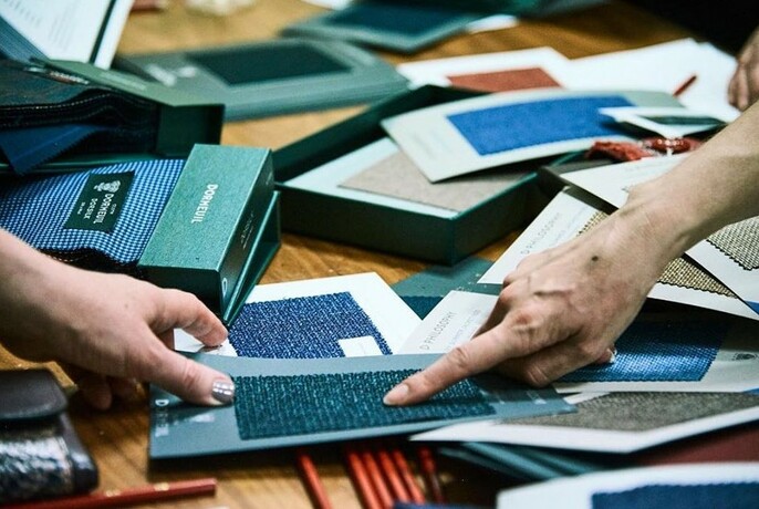 People selecting material from fabric swatches.