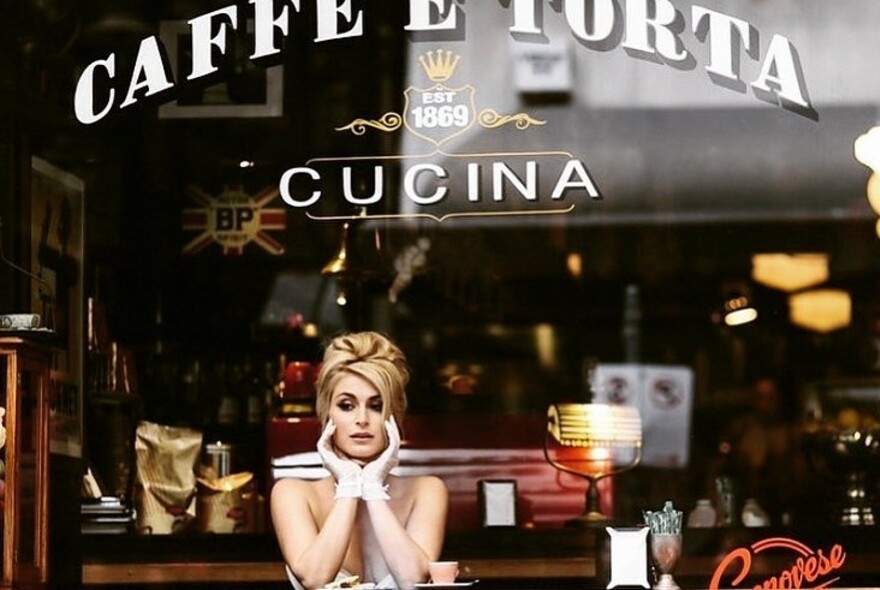 Woman in the window of Caffé E Torta in Royal Arcade.