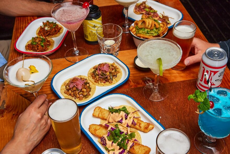 A delicious array of Mexican food and drinks on a wooden table.