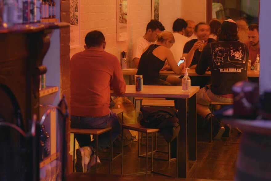 People seated in a small izakaya-style bar.